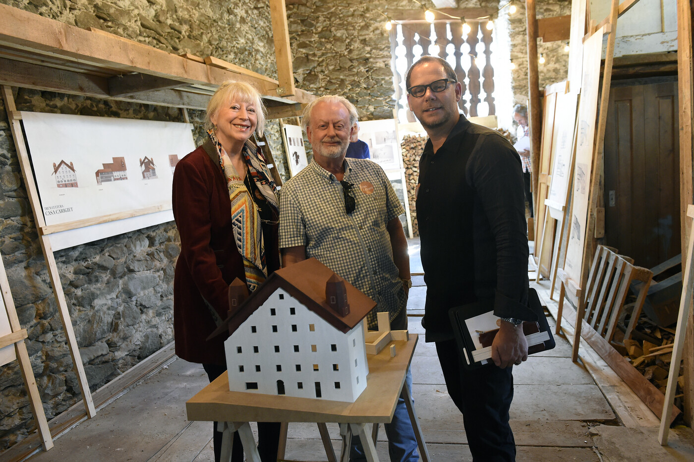 Domenica und Toni Carigiet bei der Präsentation des Wiederaufbaus der Casa Carigiet zusammen mit Architekt Remo Derungs. 