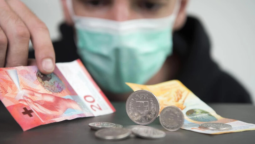 Ein Mann schaut mit einer Schutzmaske auf Schweizer Geld. Fotografiert am 15.7.20 als Themenbild zu Sozialhilfe, Corona, Konkurs, Geld unterstützung.
Bild Olivia Aebli-Item Schutzmaske Maske Geld Corona Coronavirus Coronakrise Franken Münz Münzen Sozialhilfe Konkurs Themenbild kein Geld Finanzen