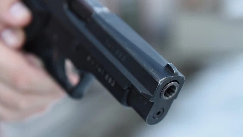 Ein Mann führt eine Ladebewegung aus, um eine 9-mm-Patrone aus einer Pistole zu entfernen.