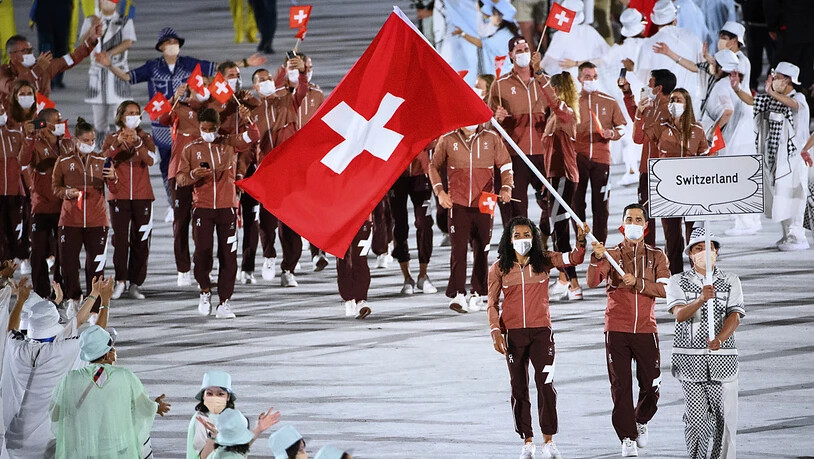 Max Heinzer und Mujinga Kambundji tragen die Schweizer Fahne ins Olympiastadion in Tokio