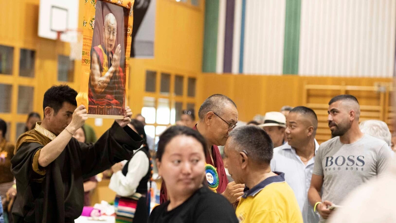 Während der Eröffnungszeremonie wird das Bild des Dalai Lama, dem spirituellen Oberhaupt des tibetischen Volkes, auf die Bühne getragen.