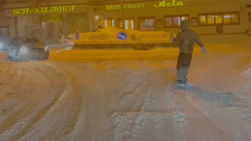 Mitten im Dorf: Der Snowboarder fährt in St. Moritz an den Autos vorbei in den Kreisel und wird dabei von einem Kollegen gefilmt. Mitten im Dorf: Der Snowboarder fährt in St. Moritz an den Autos vorbei in den Kreisel und wird dabei von einem Kollegen gefilmt.