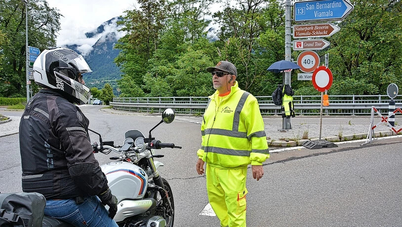 Es wird triagiert: An der Kantonsstrasse in Thusis berät der Mitarbeiter einer Sicherheitsfirma einen Motorradfahrer bei der Wahl einer Alternativroute zur gesperrten Strecke über den San Bernardino. Es wird triagiert: An der Kantonsstrasse in Thusis berät der Mitarbeiter einer Sicherheitsfirma einen Motorradfahrer bei der Wahl einer Alternativroute zur gesperrten Strecke über den San Bernardino.
