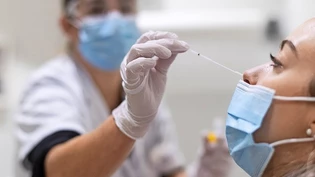 Durch die Nase: Eine Apothekerin führt bei einer Kundin einen Nasen-Rachen-Abstrich für einen Schnelltest durch.