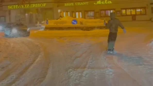 Mitten im Dorf: Der Snowboarder fährt in St. Moritz an den Autos vorbei in den Kreisel und wird dabei von einem Kollegen gefilmt. Mitten im Dorf: Der Snowboarder fährt in St. Moritz an den Autos vorbei in den Kreisel und wird dabei von einem Kollegen gefilmt.