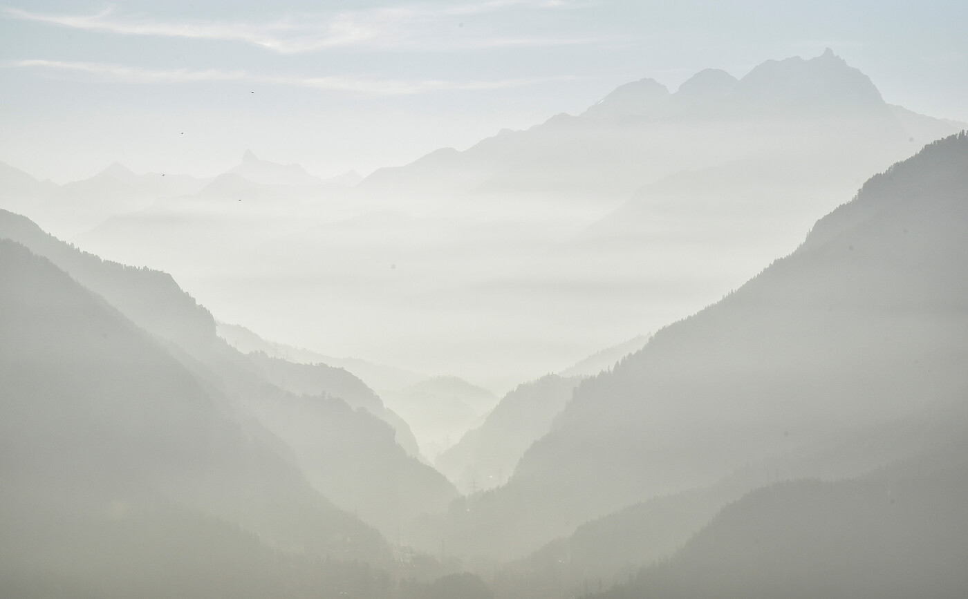 Verrauchter Blick am Montagmorgen vom Heinzenberg durch die Schinschlucht in Richtung Piz Mitgel, Tinzenhorn und Piz Ela.