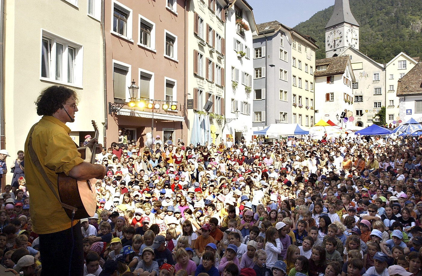 Riesiges Echo: Auf voll besetzten Bankreihen lauschen Kinder und Eltern dem Auftritt von Linard Bardill auf dem Churer Arcas.                               